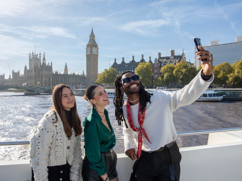 Drei Personen machen Selfie auf Schiff mit Big Ben im Hintergrund