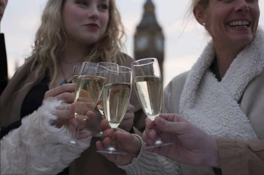 Nahaufnahme Frauen stoßen mit Getränken an in London