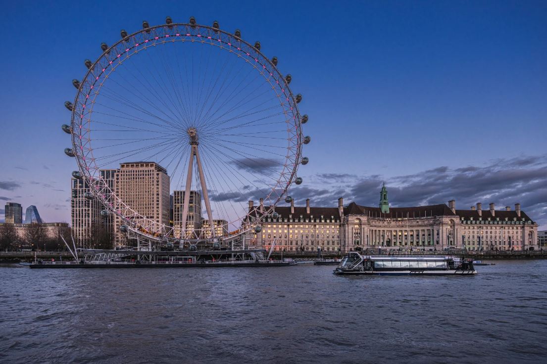 London Eye mit Fähre davor in abendlicher Stimmung