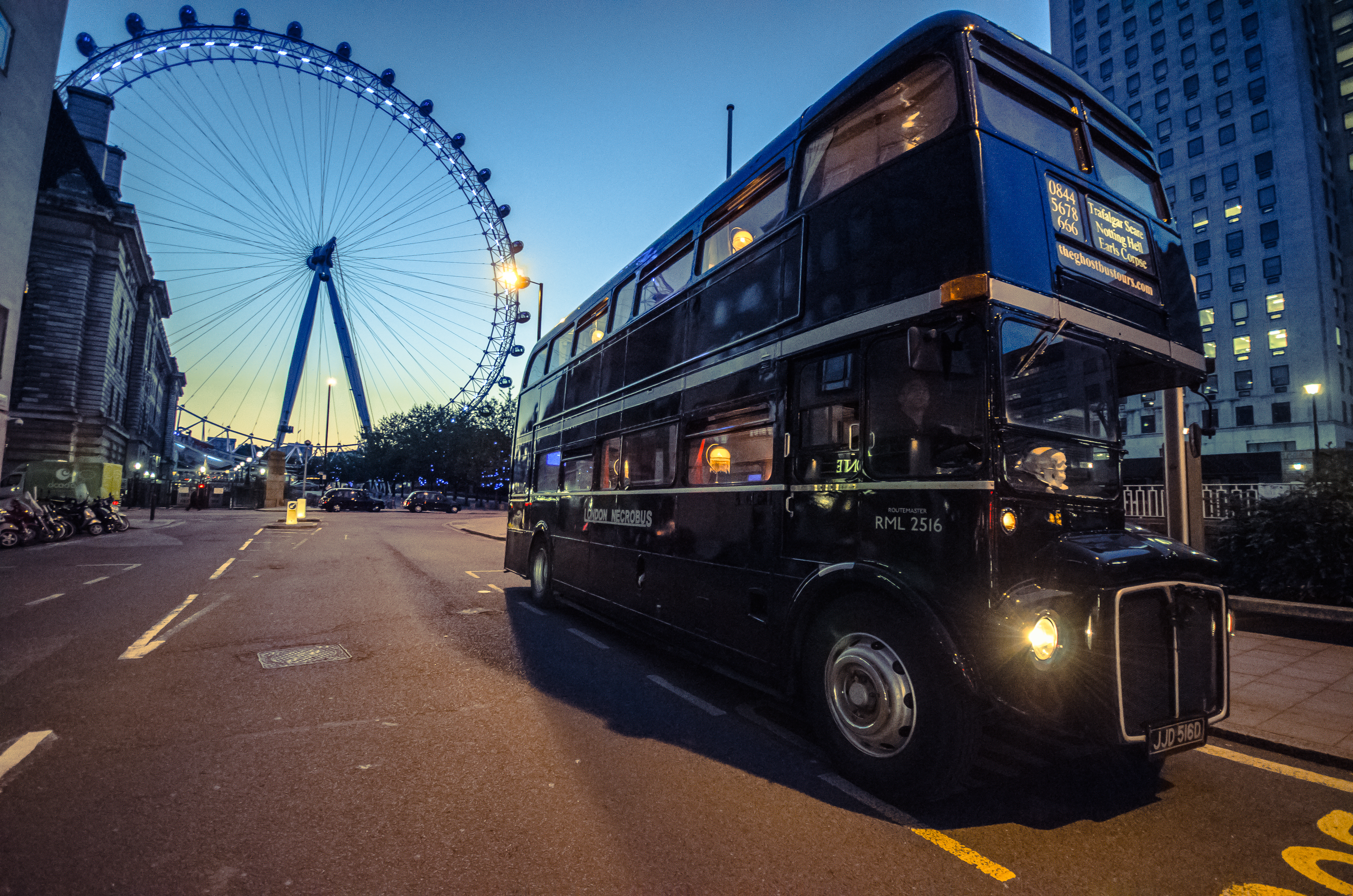 Historischer schwarzer Ghost Bus vor dem London Eye während einer abendlichen Tour durch London