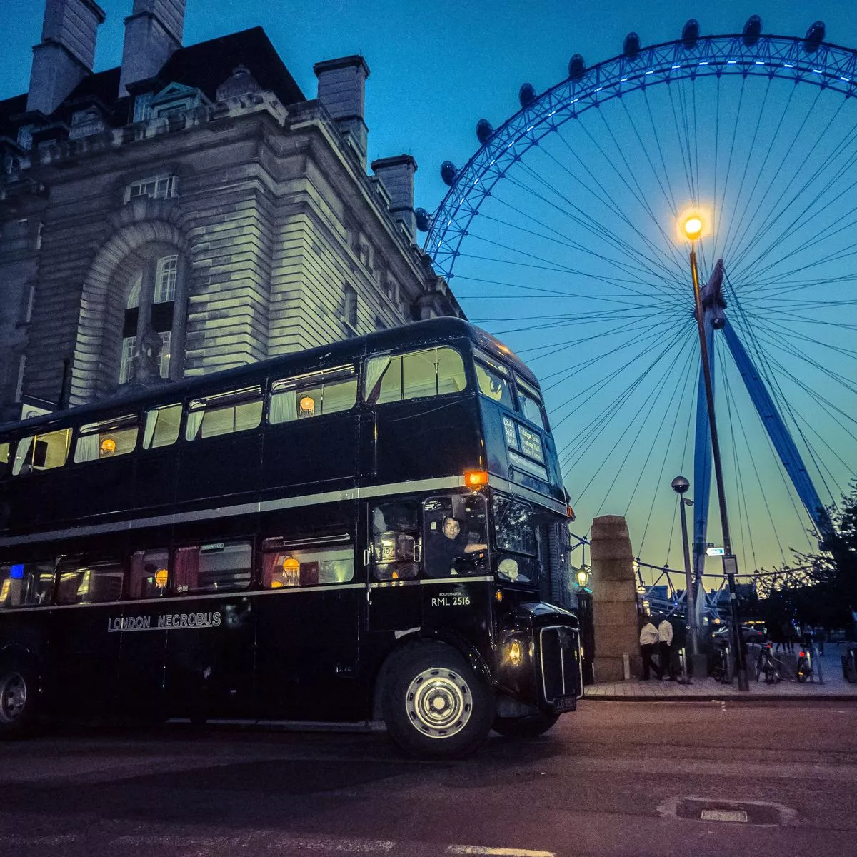 Schwarzer London Necrobus vor dem London Eye in der Abenddämmerung