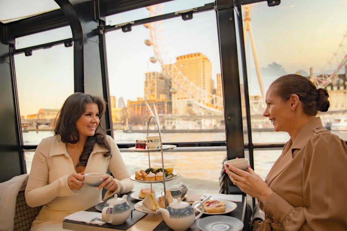 Seitenansicht Frauen sitzen sich gegenüber und lachen in London