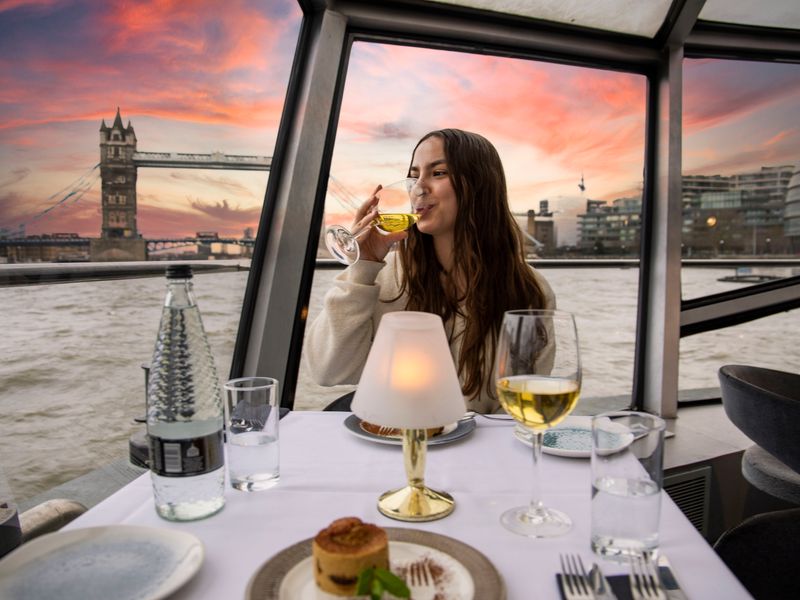 Festlich gedeckter Tisch mit Sekt und Blick auf die beleuchtete Tower Bridge bei Nacht