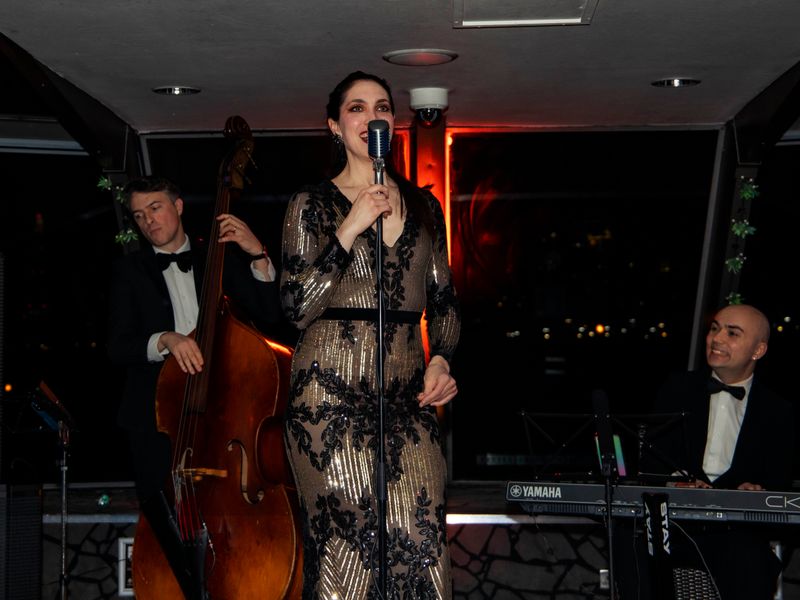 Sängerin sorgt mit Live-Musik für Unterhaltung während einer abendlichen Dinner Cruise auf der Themse