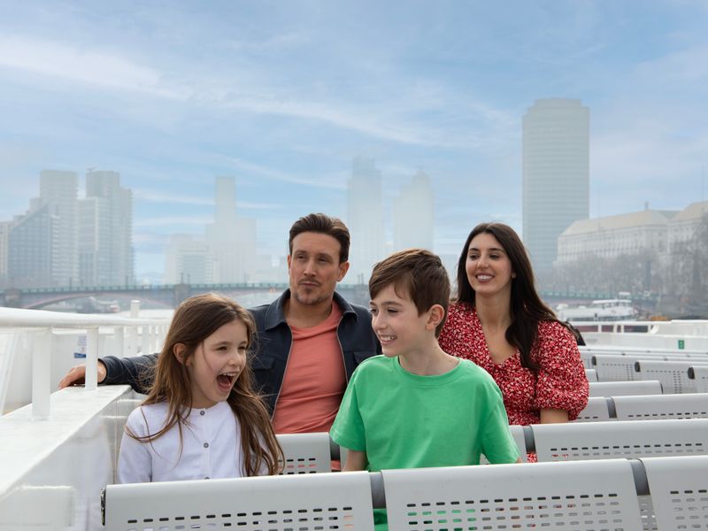 Familie mit Kindern auf Boot mit Parlament im Hintergrund & Skyline in London