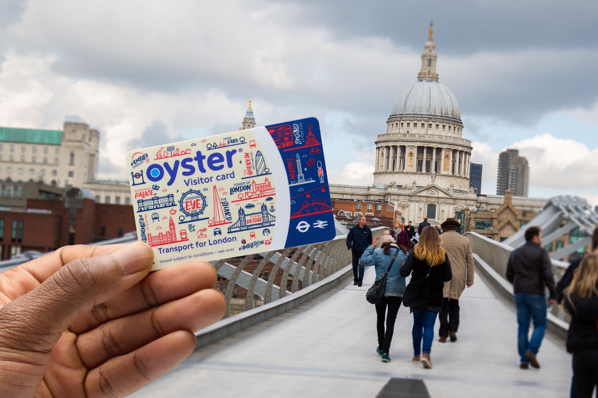 Hand hält Visitor Oyster Card mit Brücke zur St. Pauls Cathedral und Menschenmenge im Hintergrund