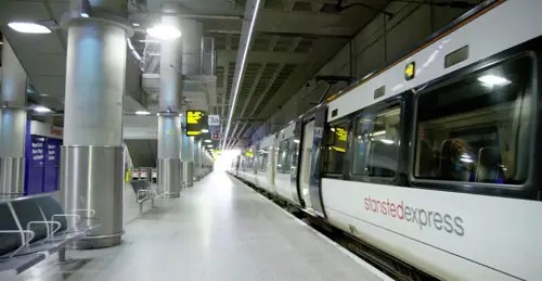 Leerer Bahnsteig mit haltendem Zug rechts in London